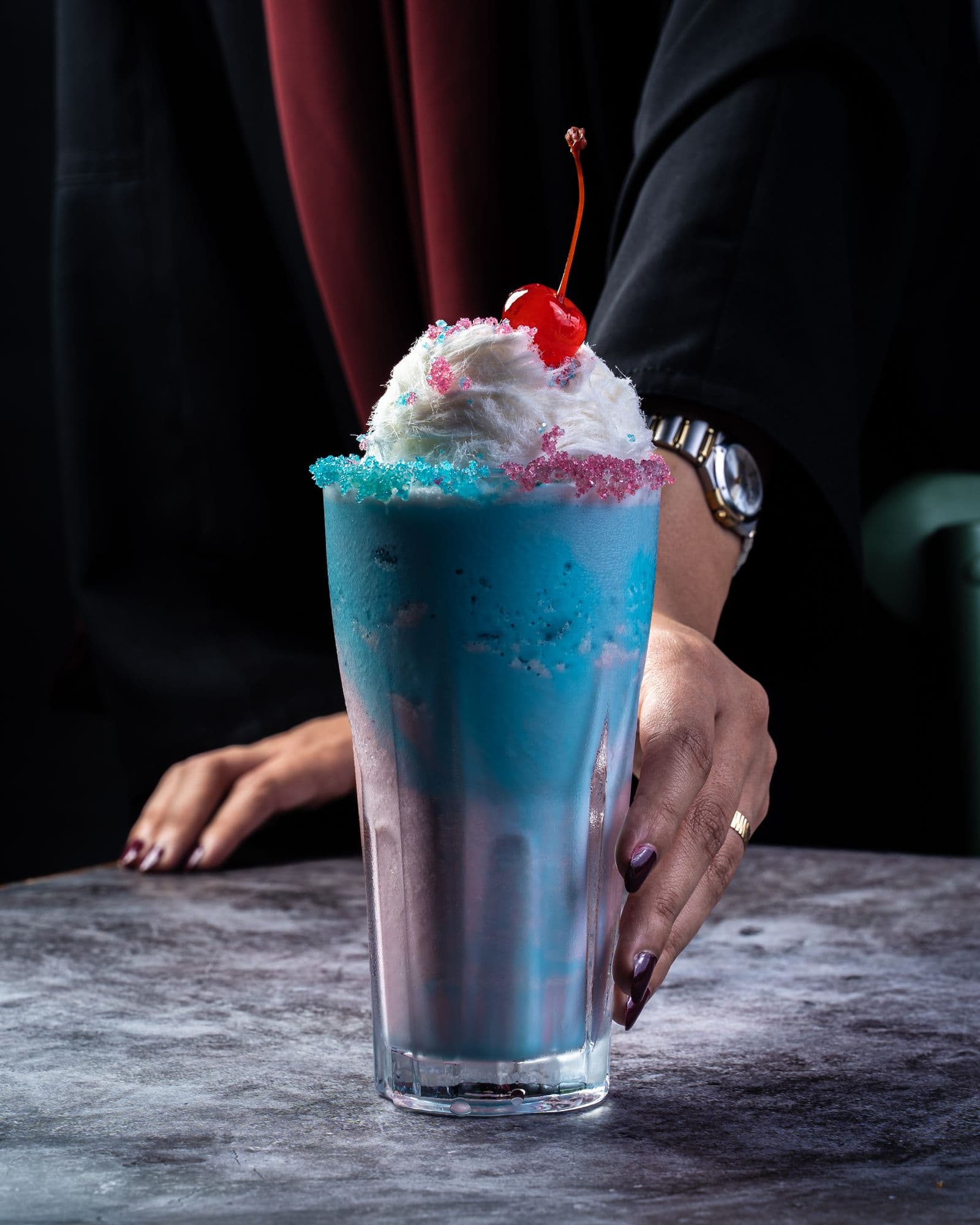 Ice cream shake topped with cream and a cherry
